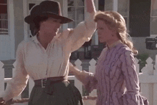 two women are standing next to each other on a porch in front of a house .