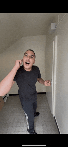 a man in a black shirt is standing in a hallway