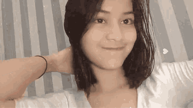 a young woman is taking a selfie with her hand on her head .