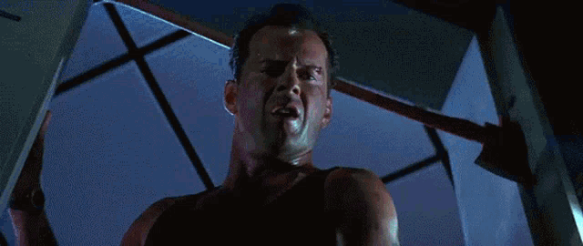 a man in a tank top is holding a large axe