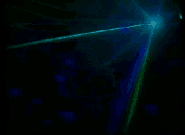 a green and blue light is coming out of a dark room