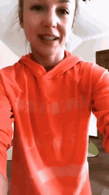 a woman is wearing a red hoodie that says columbia