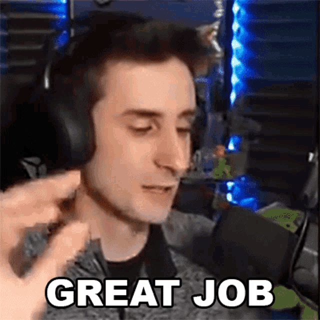 a man wearing headphones is talking into a microphone and says `` great job '' .