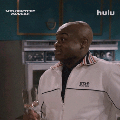 a man is holding a wine glass in front of a hulu ad