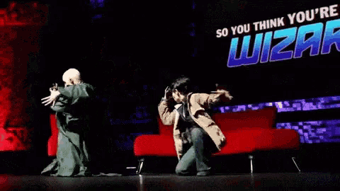 two men are dancing on stage in front of a sign that says so you think you 're wizard