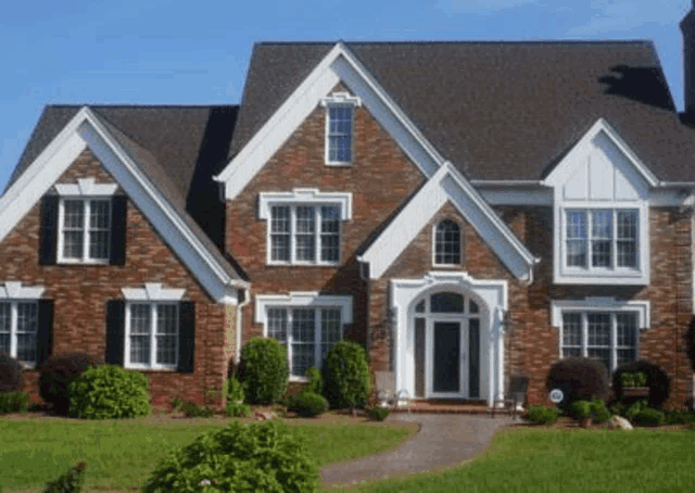 a large brick house with lots of windows and a gray roof