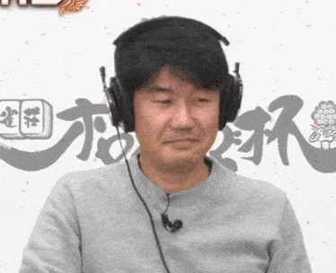 a man wearing headphones and a microphone looks at the camera