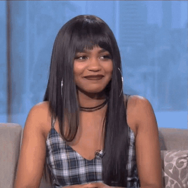 a woman with long hair and hoop earrings is laughing