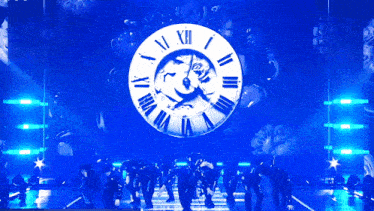 a group of people are dancing in front of a clock that says xii on it