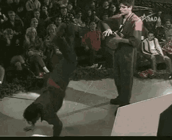 a man is doing a trick on a stage in front of a crowd with the word parada on the bottom right