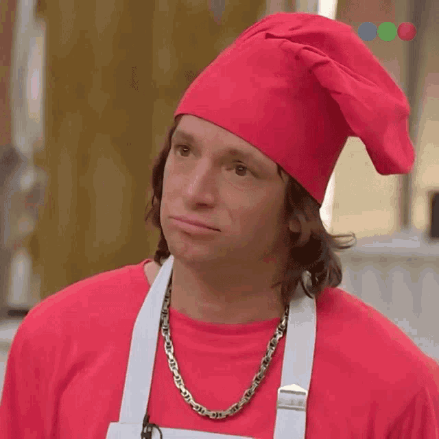 a man wearing a red hat and apron smiles