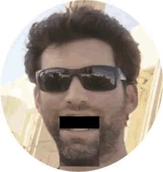 a man wearing sunglasses has his mouth covered by a black tape