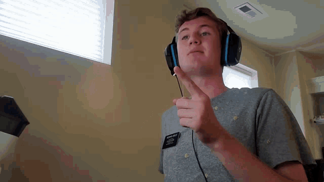 a man wearing headphones has a name tag on his shirt that says ' abercrombie & fitch '