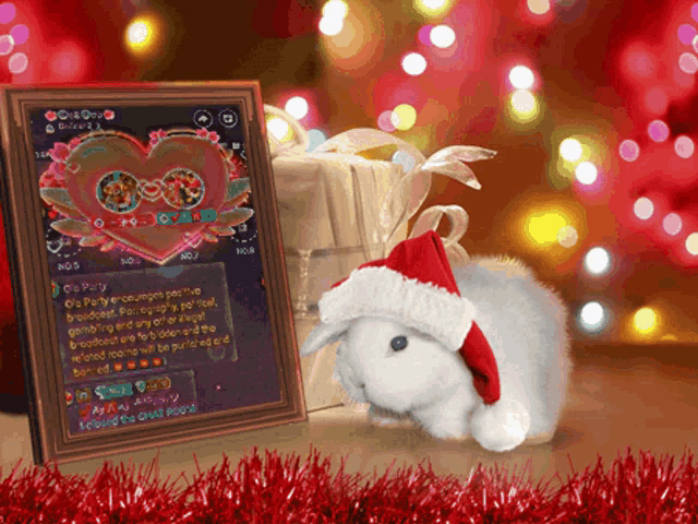 a white rabbit wearing a santa hat is sitting next to a gift
