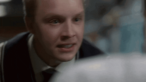 a close up of a man 's face in a suit and tie looking at something .