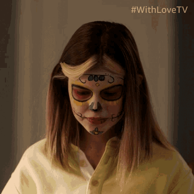 a girl with a day of the dead face paint on her face