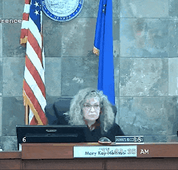 a judge sits at a desk with a sign that says mary kay