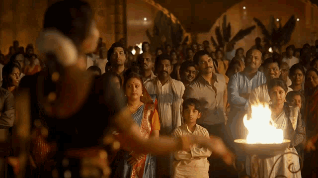 a group of people are gathered around a candle