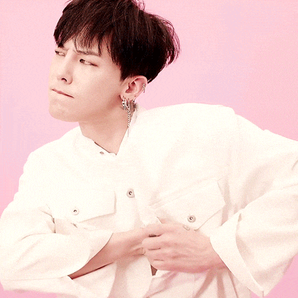 a young man wearing a white shirt and earrings looks to the side