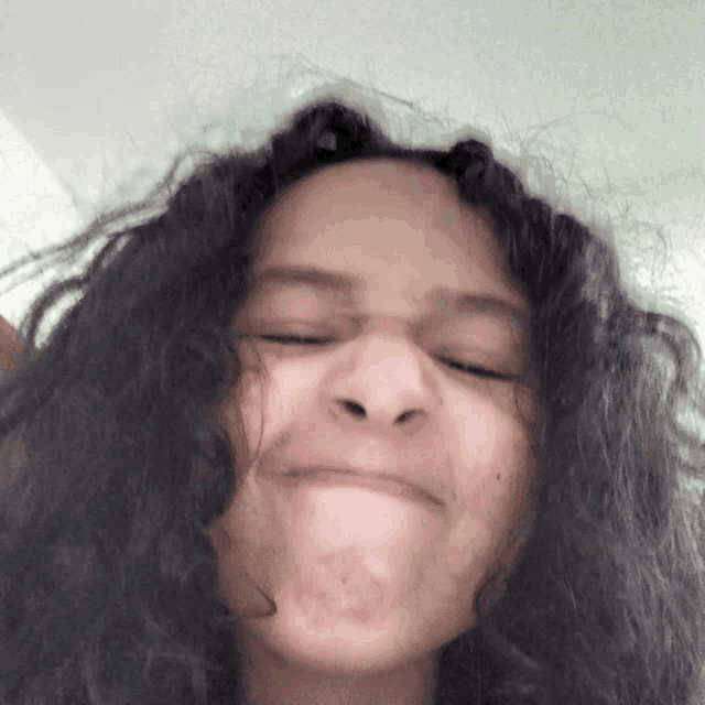 a woman with curly hair makes a funny face