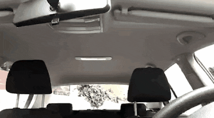 the inside of a car with a rear view mirror and headrests .
