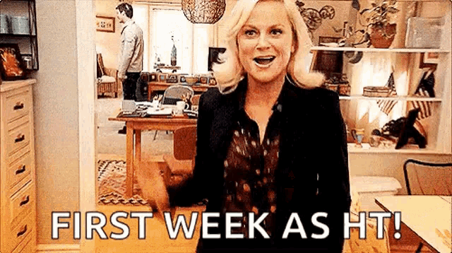 a woman is standing in a living room with the words `` first week as ht '' .