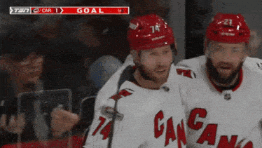 a hockey player with the number 74 on his jersey is celebrating a goal