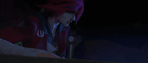 a woman with pink hair is standing in a dark room looking down .