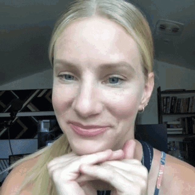 a close up of a woman 's face with her hands on her face