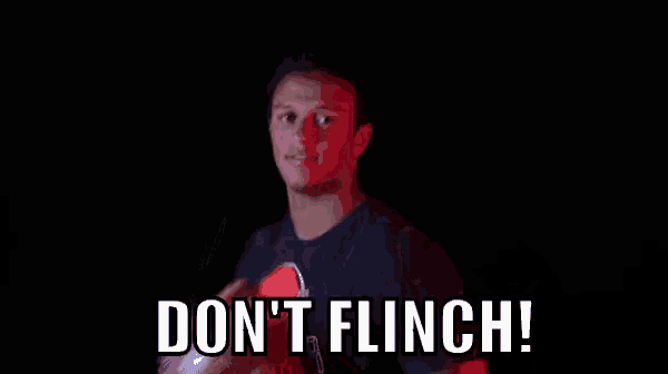a man is holding a football in his hand and says `` don 't flinch '' .