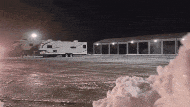 a rv is parked in a parking lot at night
