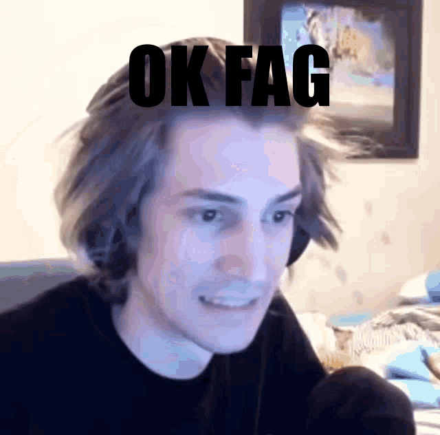 a man wearing headphones and a black shirt with the words ok fag on his head