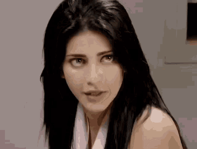 a woman with long black hair is wearing a purple scarf around her neck .