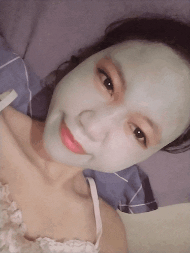 a woman with a green face mask on her face