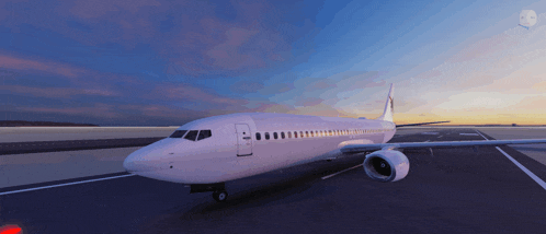 a white airplane is parked on a runway with a sunset in the background