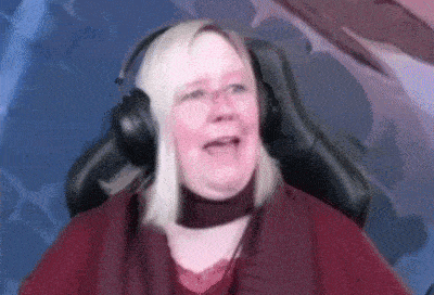 a woman wearing headphones and a red shirt is sitting in a chair .