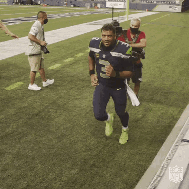 a man in a number 5 jersey is running on a field