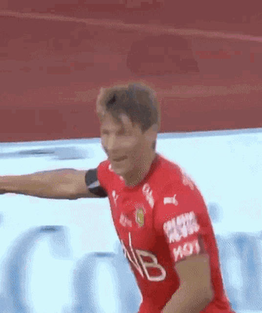 a man in a red shirt with the letter b on the sleeves
