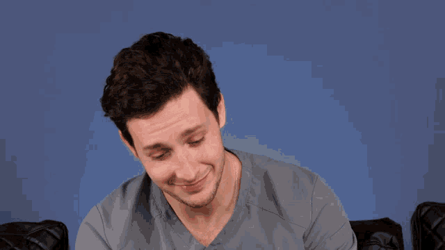 a man in a grey scrub top is making a face