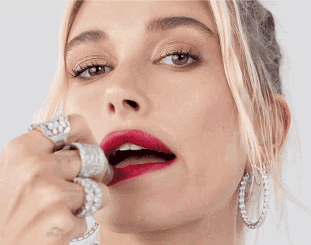 a close up of a woman 's face with red lipstick