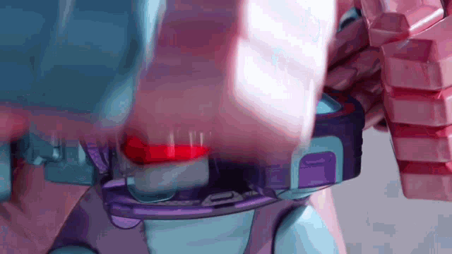 a person is holding a pink and purple toy with a red button