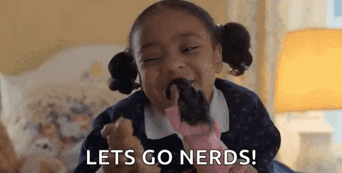 a little girl is holding a doll and saying `` let 's go nerds '' .