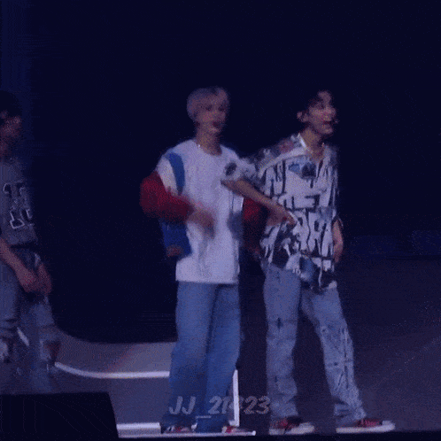 a group of people are dancing on a stage in front of a large we sign