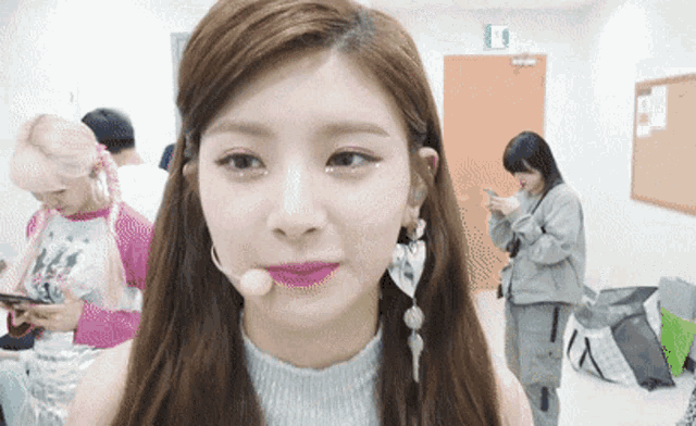 a girl with a microphone in her mouth looks at the camera