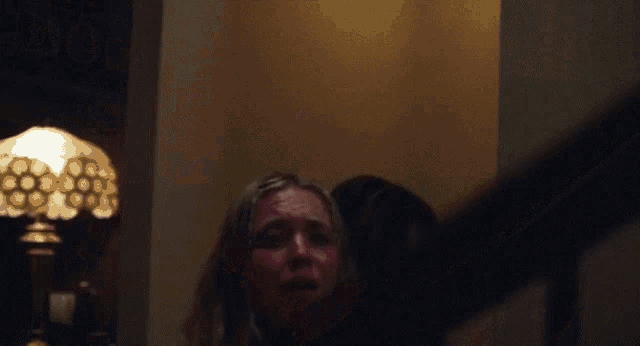 a woman in a pink bikini is being held by another woman on a set of stairs