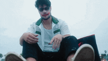 a man with blood on his face is wearing a white shirt that says t-shirt
