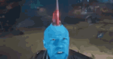 a man with a blue face and a red mohawk is wearing a black jacket .
