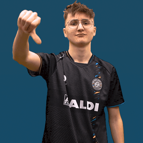 a young man wearing a black aldi shirt giving a thumbs down sign