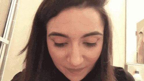 a close up of a woman 's face with her eyes closed and her hair blowing in the wind .