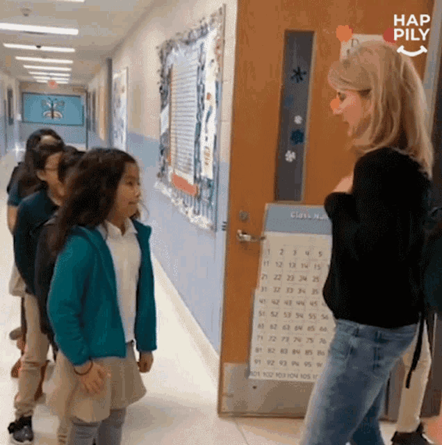 a girl in a blue jacket is talking to a teacher in a hallway with hap pily written in the corner